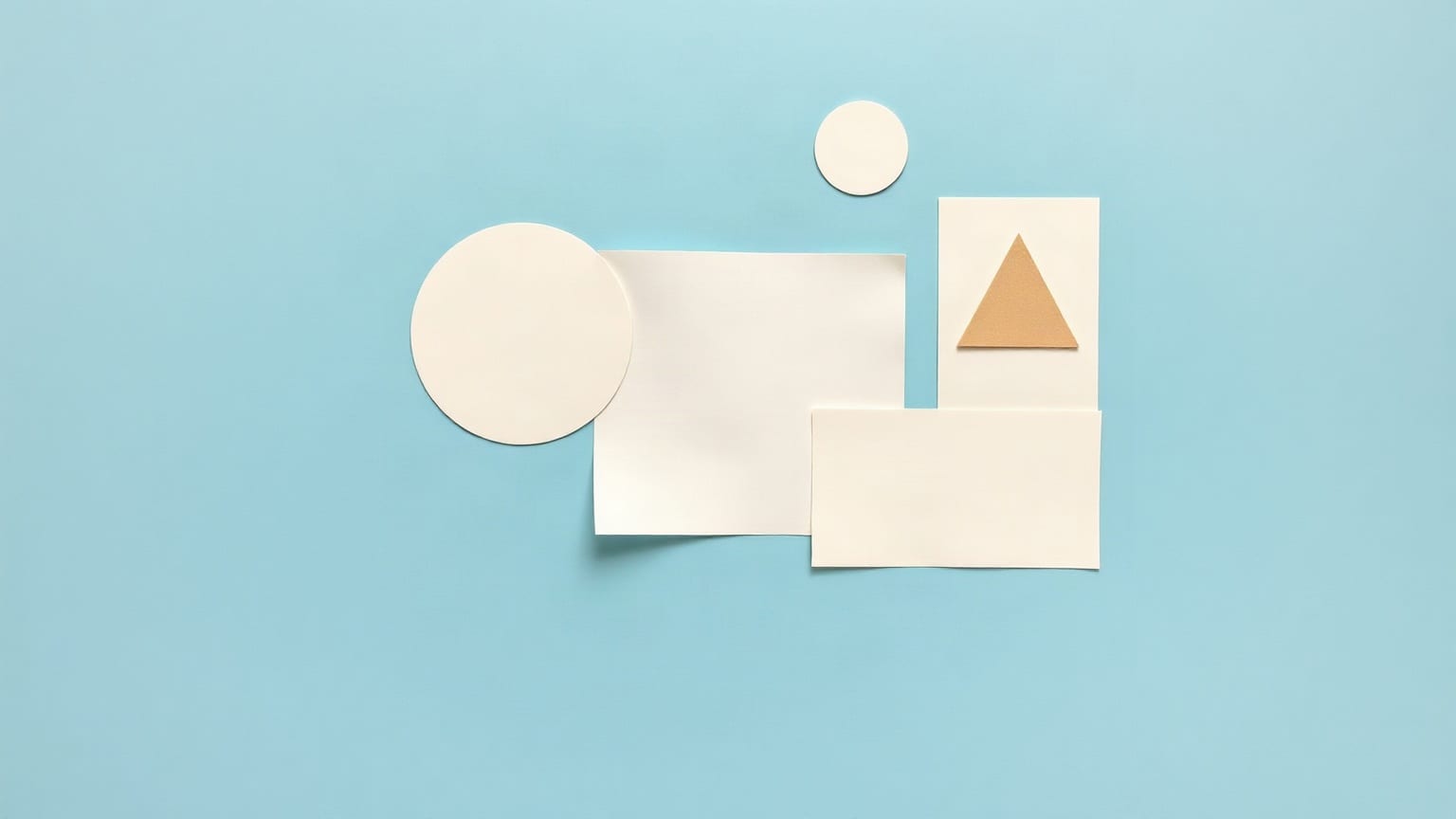 Overlapping flat paper shapes — two circles, two rectangles and a sand triangle — on a clear blue ground