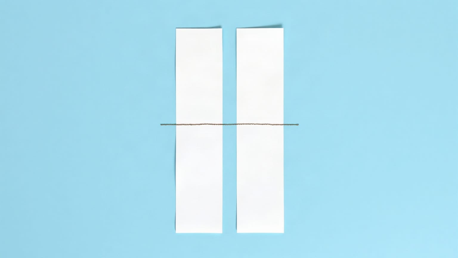 Two chalk-white paper bars on a clear mid-blue ground, the taller one narrow and the shorter one wide, a thin pale sky line between them